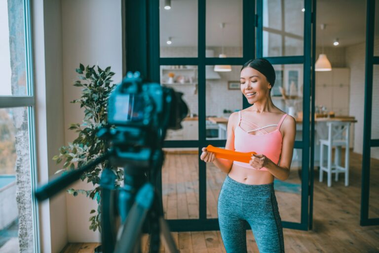 Fitness trainer speaking about resistance bands while filming video